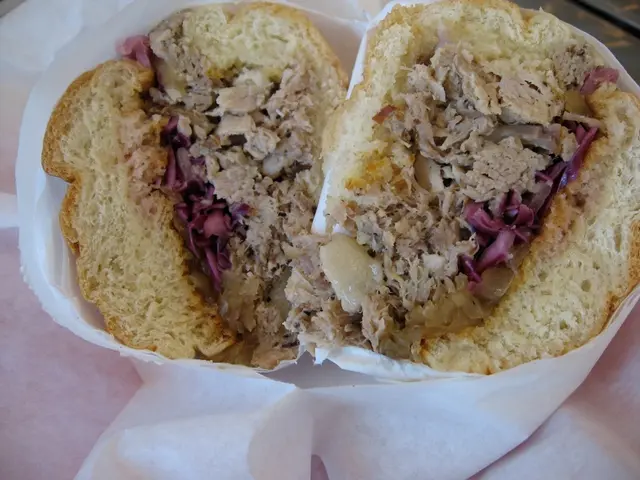 In the picture we can see a paper made cup with two bread slices in it we can see some vegetable...