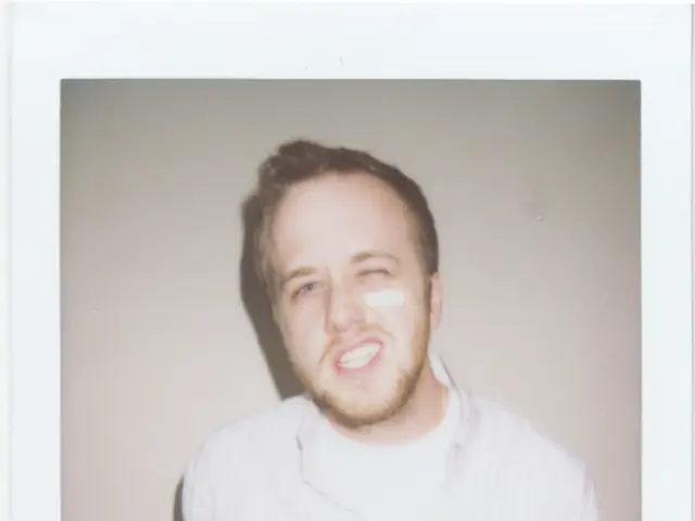 In the image we can see there is a photo of a person standing and he is blinking his eye.