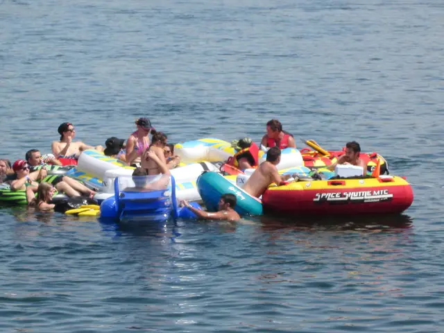 In this image we can see people sitting in tubes and we can also see water.